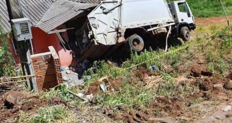 Caminhão de coleta de lixo tomba sobre residência